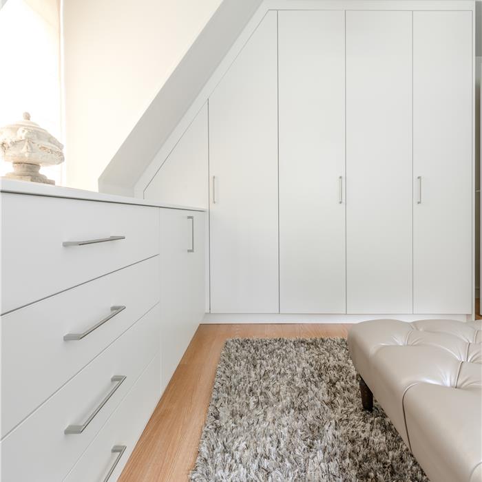 Witte maatkast in dressing aangepast aan de schuine dakhelling