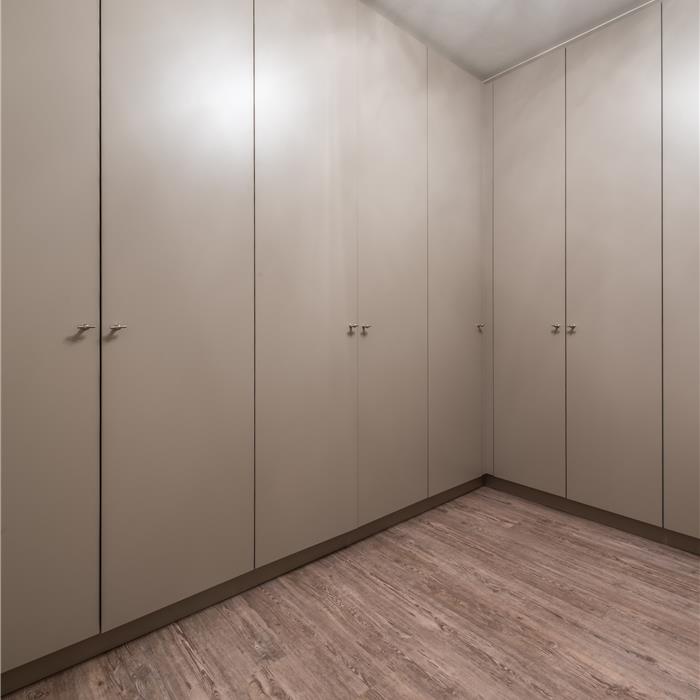 Crèmekleurige maatkast in decor met RVS knopgrepen in dressing in Mortsel