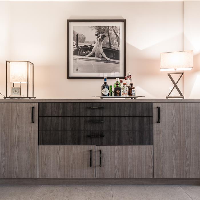 Maatwerk dressoir in grijs houtdecor met donker ladeblok en zwarte grepen