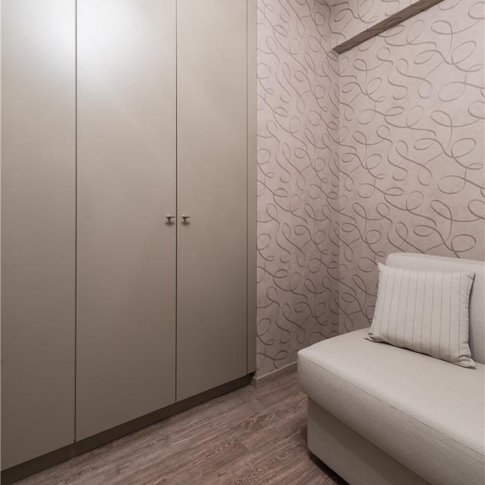 Hoge crèmekleurige dressingkasten op maat over de volledige wand