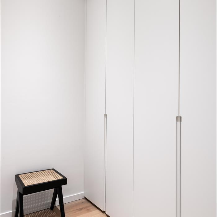 Kamerhoge witte maatkasten in smalle dressing op maat