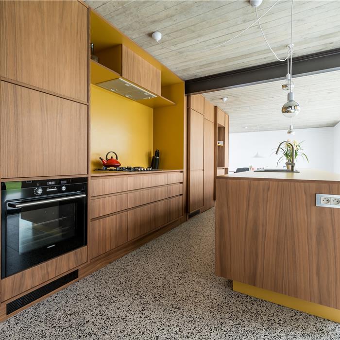 keuken op maat in Vorselaar, zicht op oven, kookfornuis, eiland en maatkasten in notelaar
