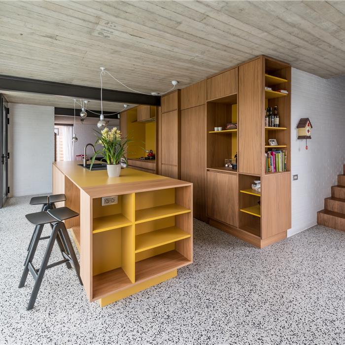 keuken op maat in Vorselaar, met eiland en maatkasten in notelaar, zicht op het eiland met zitplek, en de maatkasten die keuken met living verbinden