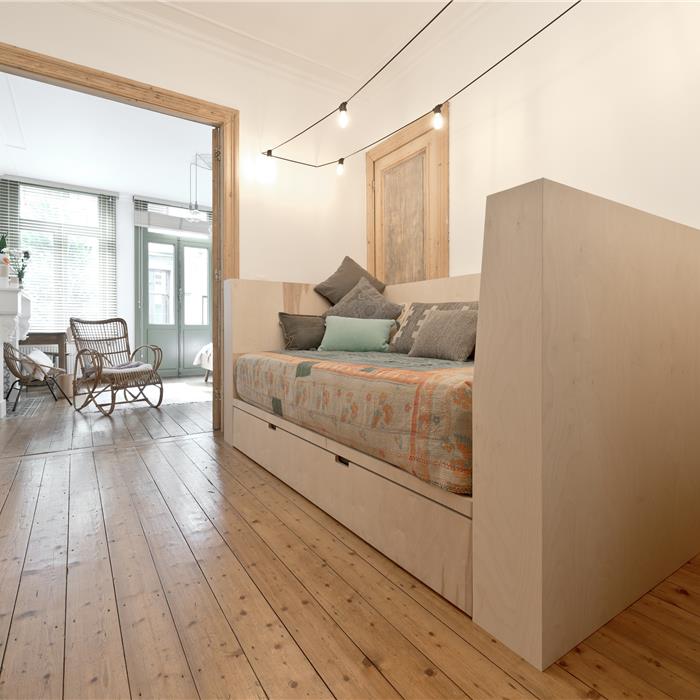 Zij-aanzicht van zetelbed met opbergruimte in berken multiplex die Interieur Van Gool als schrijnwerker realiseerde voor deze bed and breakfast