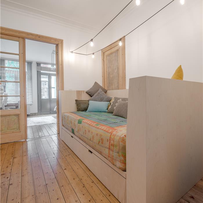 Zij-aanzicht van zetelbed met opbergruimte in berken multiplex die Interieur Van Gool als schrijnwerker realiseerde voor deze bed and breakfast