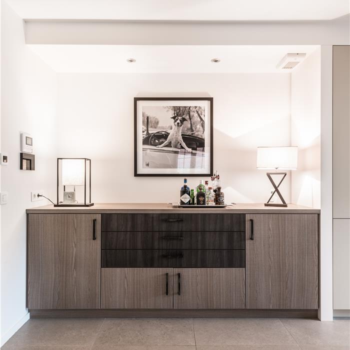 Breed maatwerk dressoir met deuren en laden in een woonkamer in Zoersel