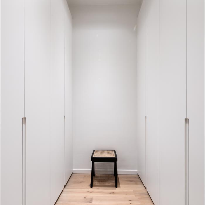 Witte dressing met kamerhoge maatkasten aan weerszijden in Antwerpen,