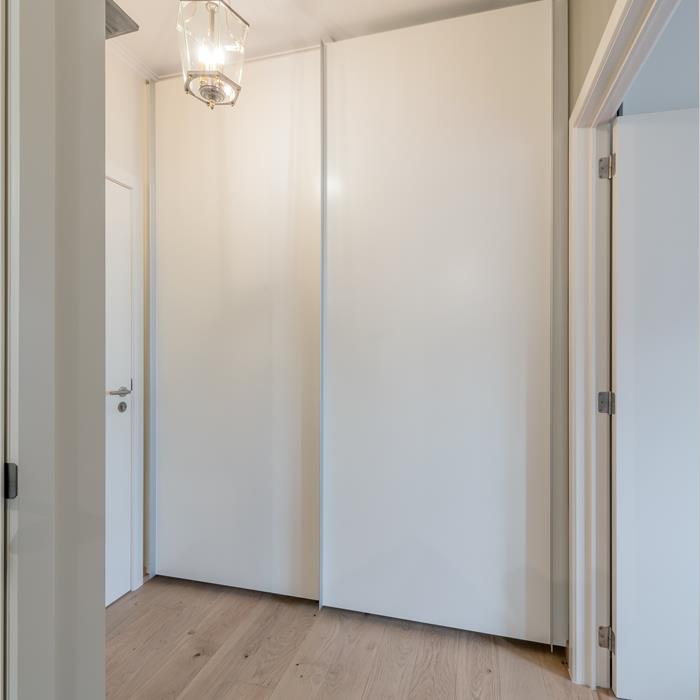 Witte ingebouwde maatkast van vloer tot plafond in de hal in Wuustwezel
