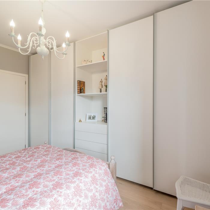 Witte maatkast in slaapkamer in Wuustwezel met open vakken en geïntegreerde laden