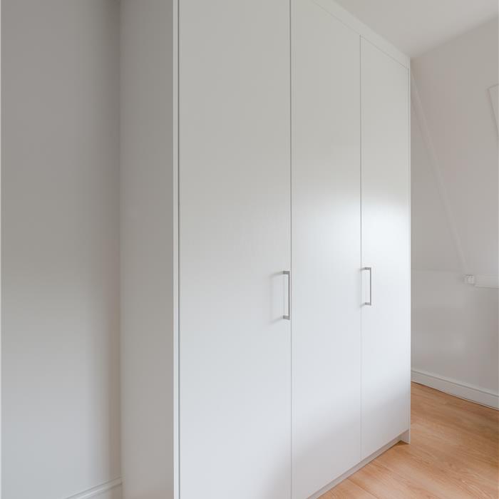 Witte slaapkamerkast op maat met drie deuren en RVS-look grepen