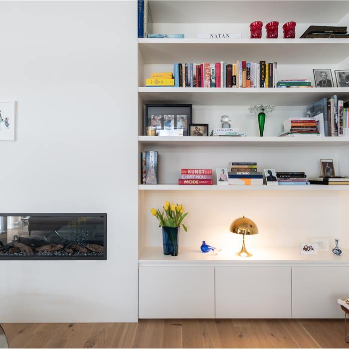Witte maatkast met open wandplanken en gesloten kasten in woonkamer in Antwerpen