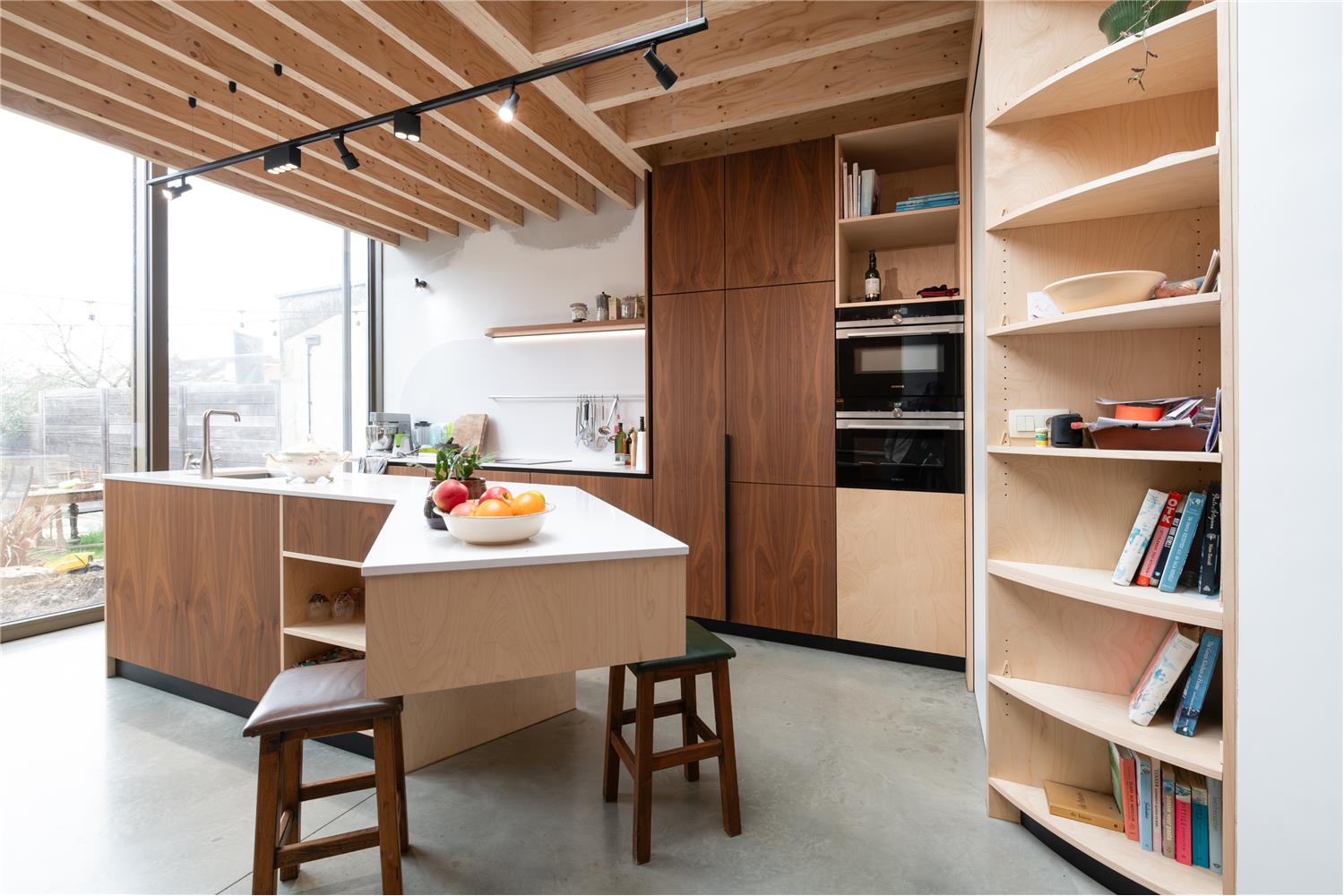 Keukenkasten en eiland als onderdeel van de keuken en maatkasten in notelaar en berkenfineer in Leuven.