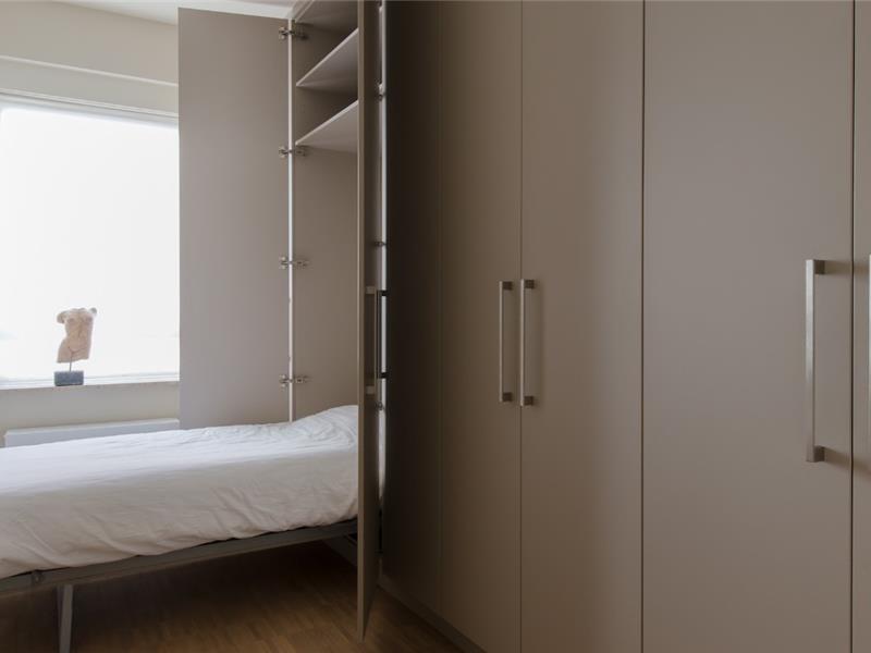 Kastenwand met geïntegreerd opklapbed op maat in logeerkamer in Antwerpen