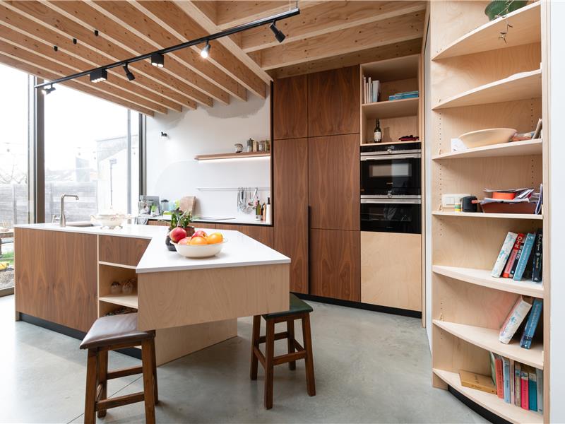 Keukenkasten en eiland als onderdeel van de keuken en maatkasten in notelaar en berkenfineer in Leuven.