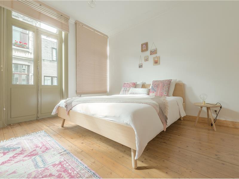 Ingebouwd zetelbed met opbergruimte in berkenmultiplex als onderdeel van de maatkasten voor deze bed and breakfast in Antwerpen.